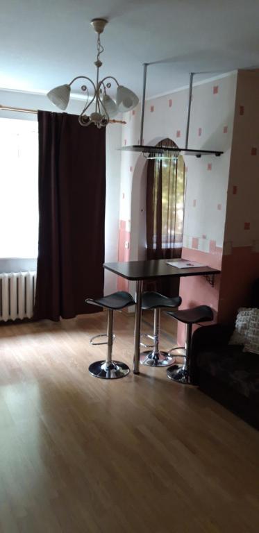 een woonkamer met een tafel en 2 krukken bij Airport Apartment in Tallinn