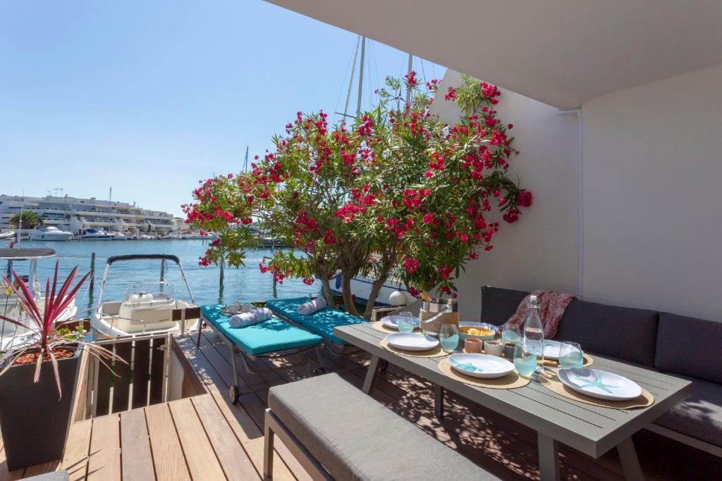 - une table sur un balcon avec des fleurs sur un bateau dans l'établissement Superbe Marina Spacieuse en face de la Plage!, au Grau-du-Roi