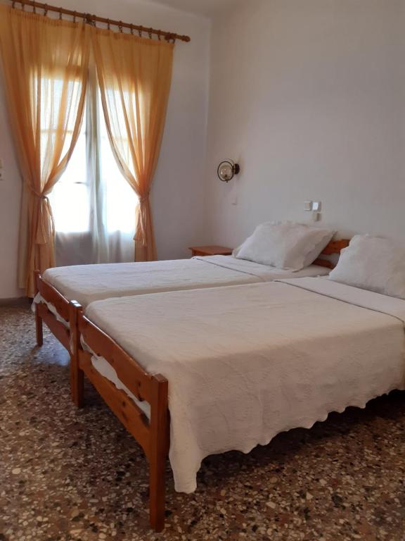 een slaapkamer met 2 bedden en een raam bij Hotel George in Chrysi Ammoudia