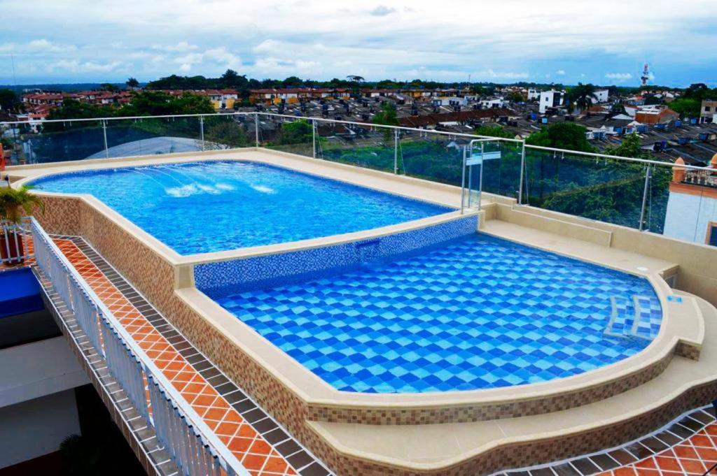a large swimming pool on the roof of a building at Hotel Hacaritama Colonial in Villavicencio