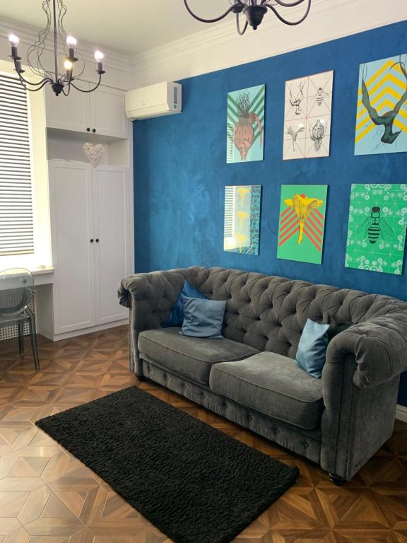 ein Wohnzimmer mit Sofa und blauen Wänden in der Unterkunft Квартира Титова 12 in Dnipro