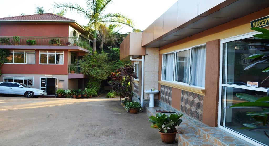 a building with a car parked in front of it at Comfort Hotel Entebbe in Lyamutundwe