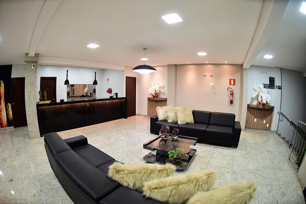 a living room with two couches and a table at TOPÁZIO IMPERIAL HOTEL in Itaúna