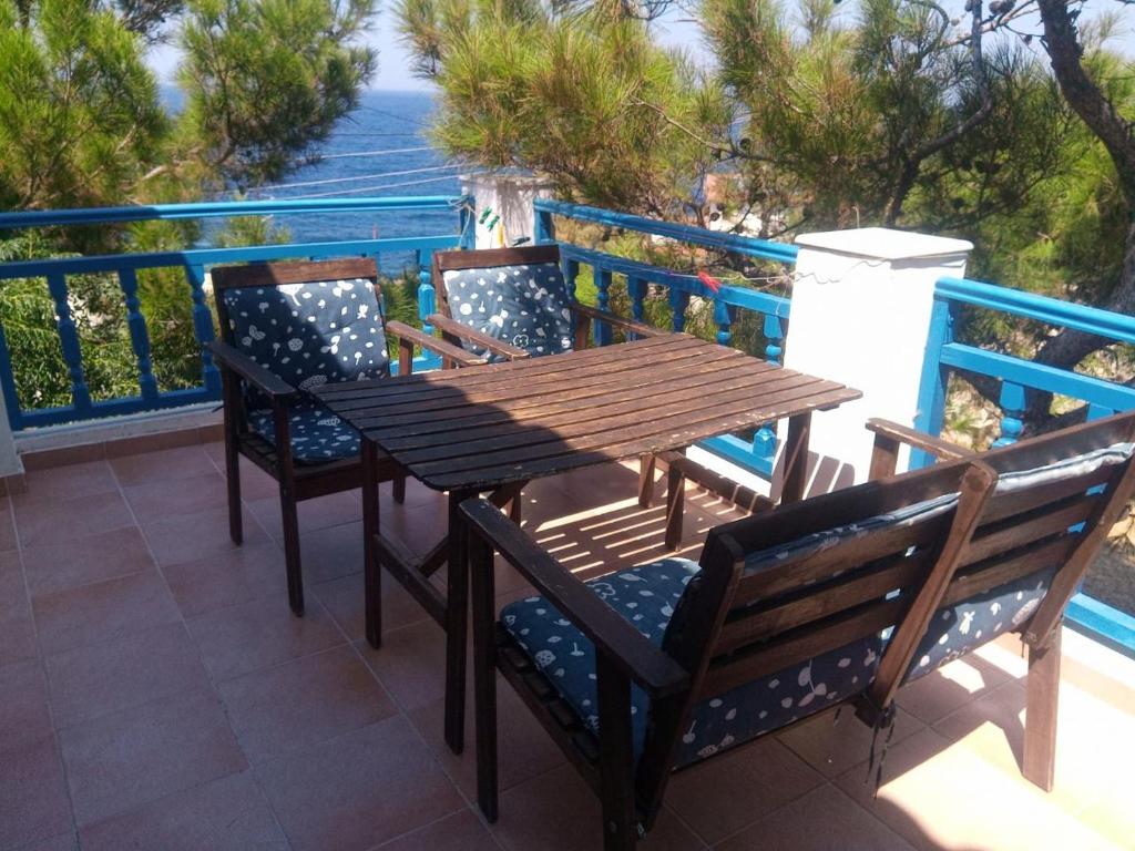 a wooden table and chairs sitting on a balcony at Pefka Armenistis in Armenistis