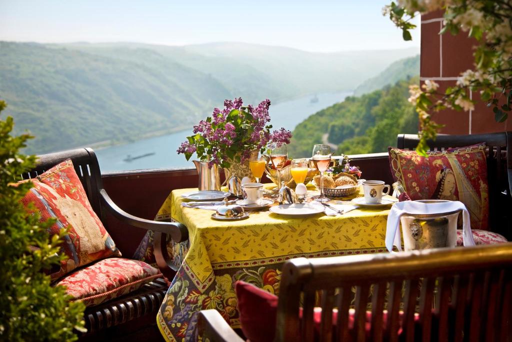 una mesa con comida y bebida en la parte superior de un balcón en Burghotel auf Schönburg, en Oberwesel