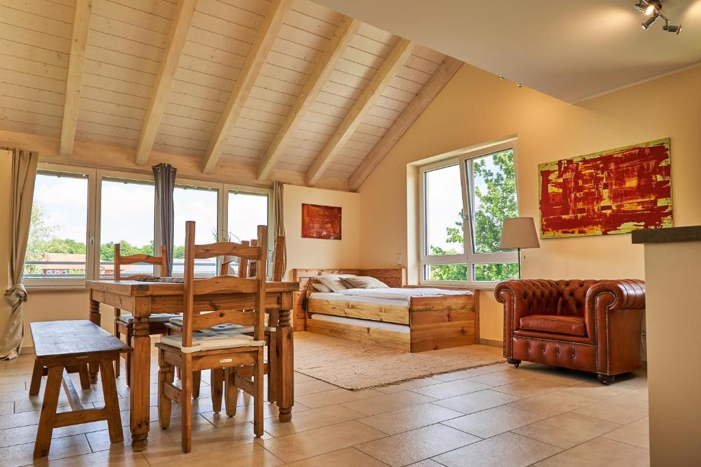 ein Wohnzimmer mit einem Bett, einem Tisch und Stühlen in der Unterkunft Ferienwohnungen Gut Mischenried in Weßling