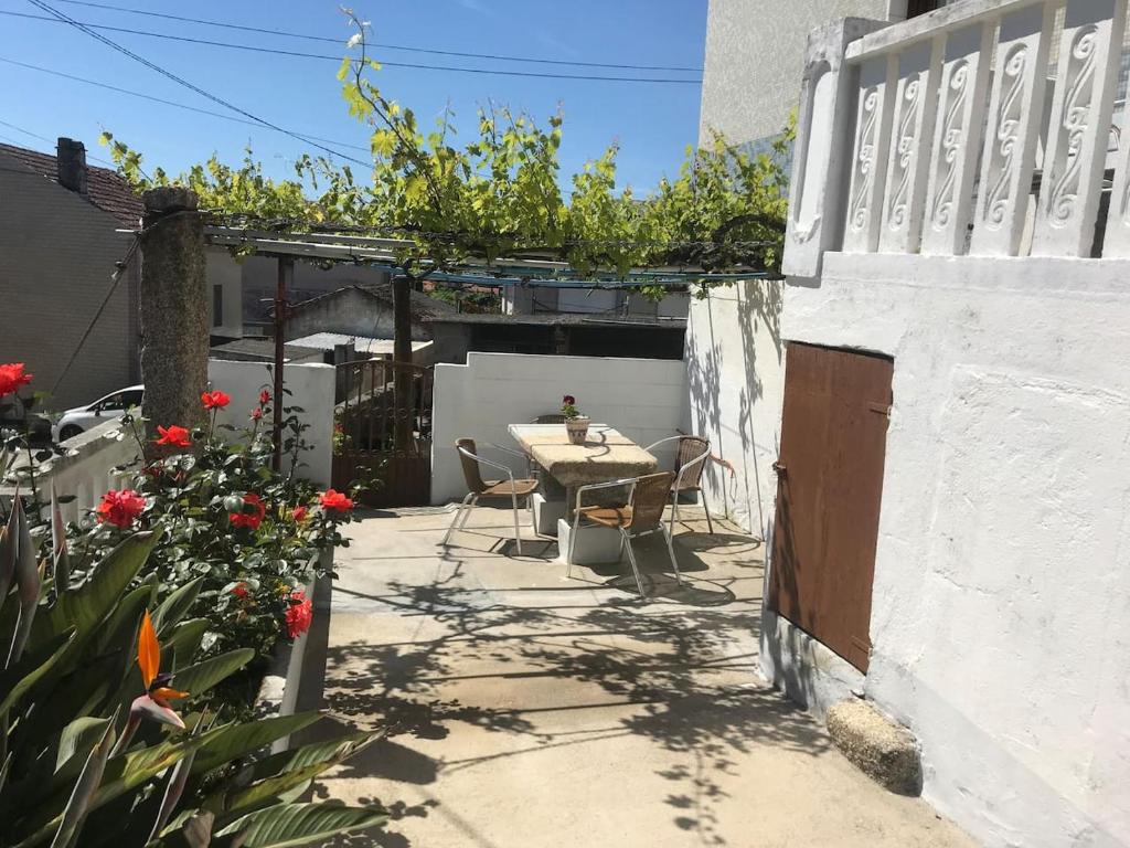 a patio with a table and chairs and flowers at Casa A Illa de Arousa in Isla de Arosa