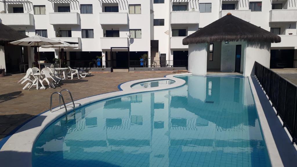una gran piscina frente a un edificio en Resort Villa da praia apto 30 arraial do cabo en Arraial do Cabo