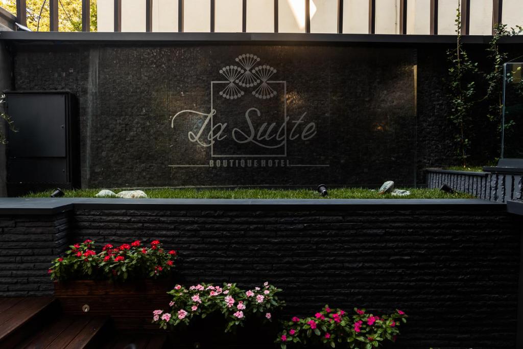 a sign for a be suite restaurant with flowers at La Suite Boutique Hotel in Tirana