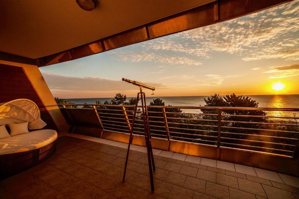 a view of the ocean from a balcony with a telescope at Hotel Dom Zdrojowy Prywatny Apartament 359 Lazurowa Gondola in Jastarnia