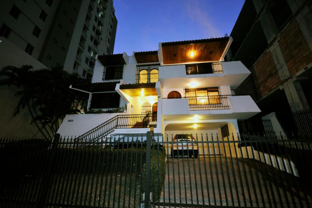 ein weißes Haus mit einem Zaun davor in der Unterkunft Totumas Lodge in Panama-Stadt