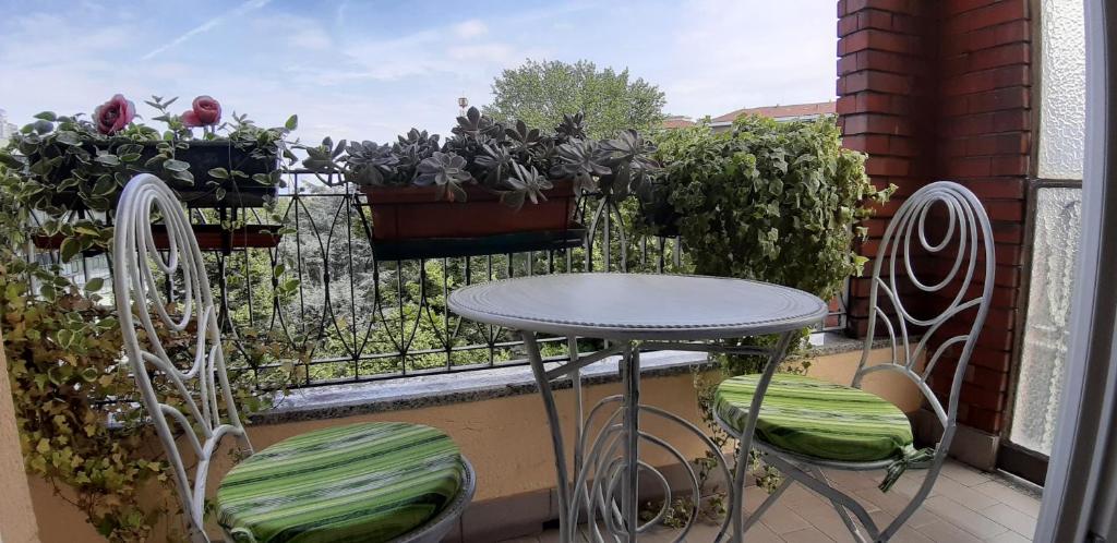 un tavolo e 2 sedie seduti su un balcone di Casa RA a Torino