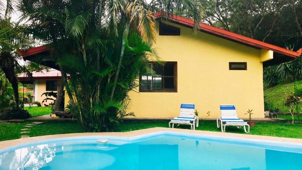 uma casa com duas cadeiras e uma piscina em Hacienda Sassenberg em Miramar