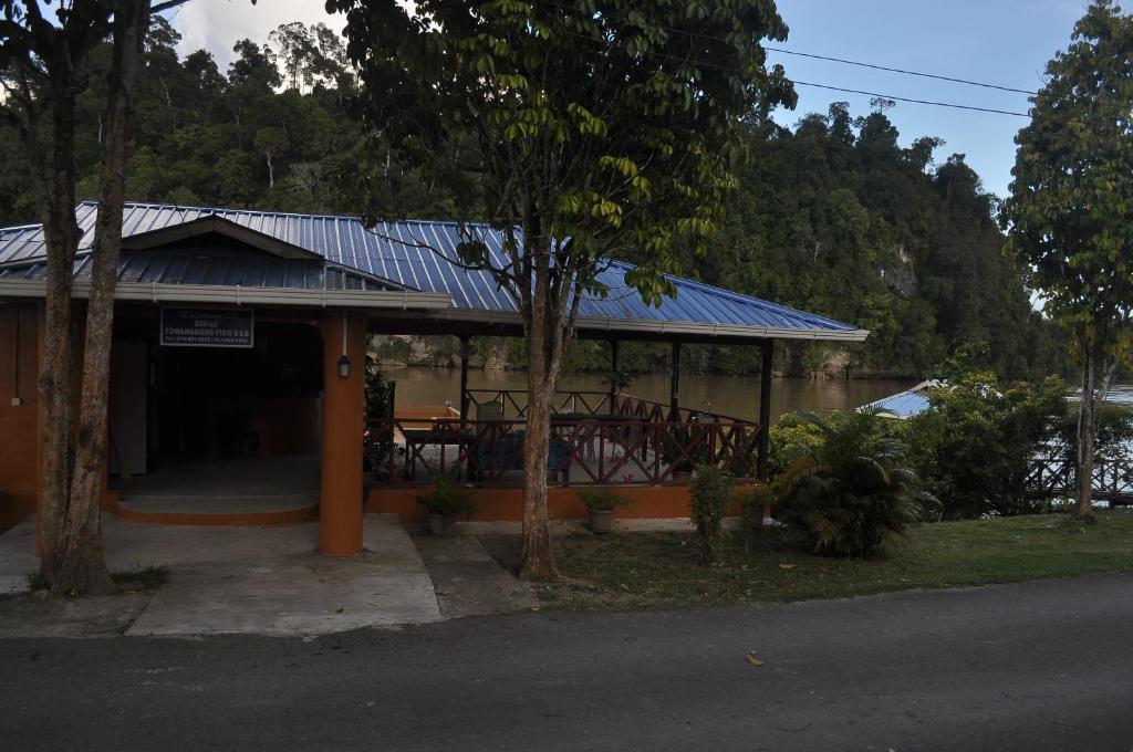 a building with a blue roof with a table at Sukau tomanggong view bed & breakfast in Sukau