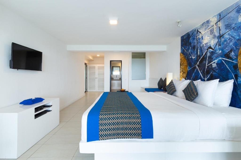 a bedroom with a large bed and a tv at The Theva Residency in Kandy