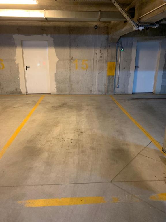 an empty parking garage with two white doors and yellow lines at Listopadowa43 - z garażem in Bielsko-Biała