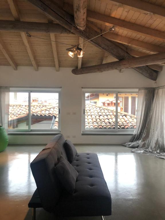 Una sala de estar con un sofá y dos ventanas. en BLoft Charme&Relax, en Bérgamo