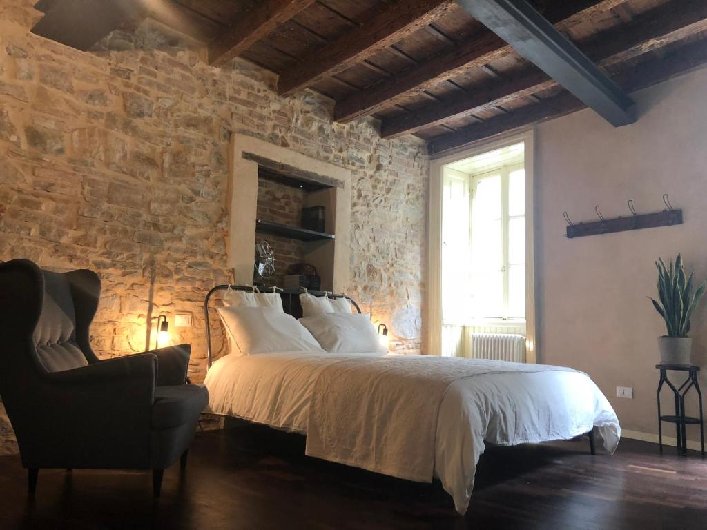 1 dormitorio con 1 cama grande y 1 silla en Olivia Suite Charme&Relax, en Bérgamo