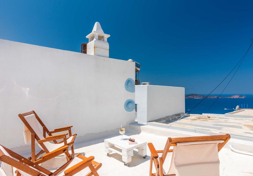 a couple of chairs and a table on a roof at Sunset Nest in Plaka Milou