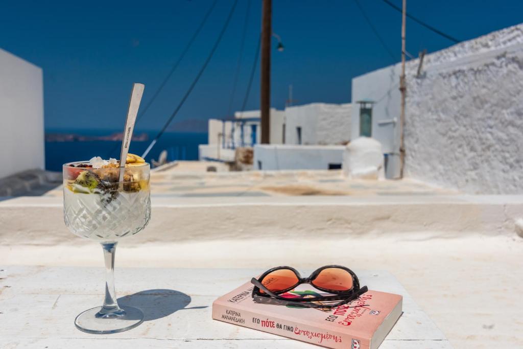 a glass of wine and a pair of sunglasses on a table at Sunset Nest in Plaka Milou