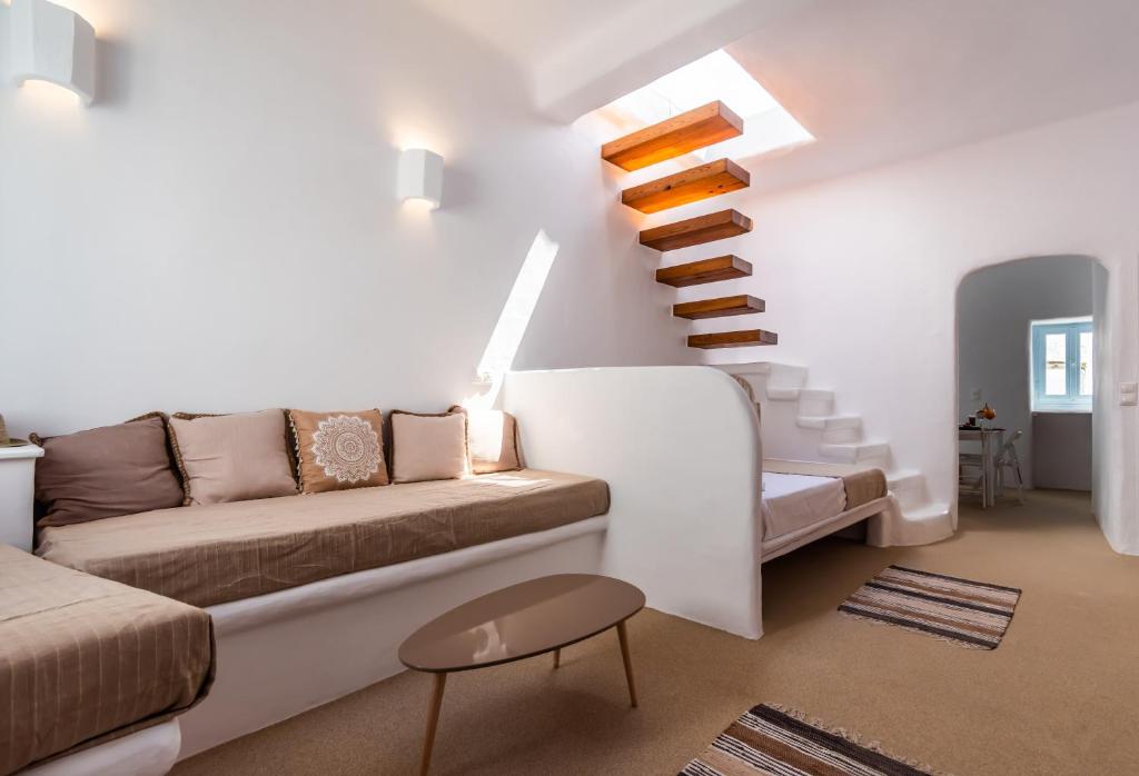a living room with a couch and a staircase at Sunset Nest in Plaka Milou