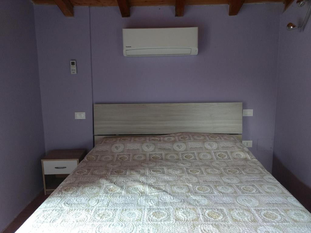 a bedroom with a bed in a purple wall at Casetta in Sassi in Varzi
