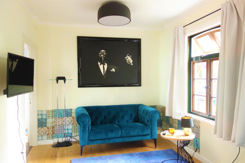 ein Wohnzimmer mit einem blauen Sofa und einem TV in der Unterkunft FeWo Schuster in Garlstorf