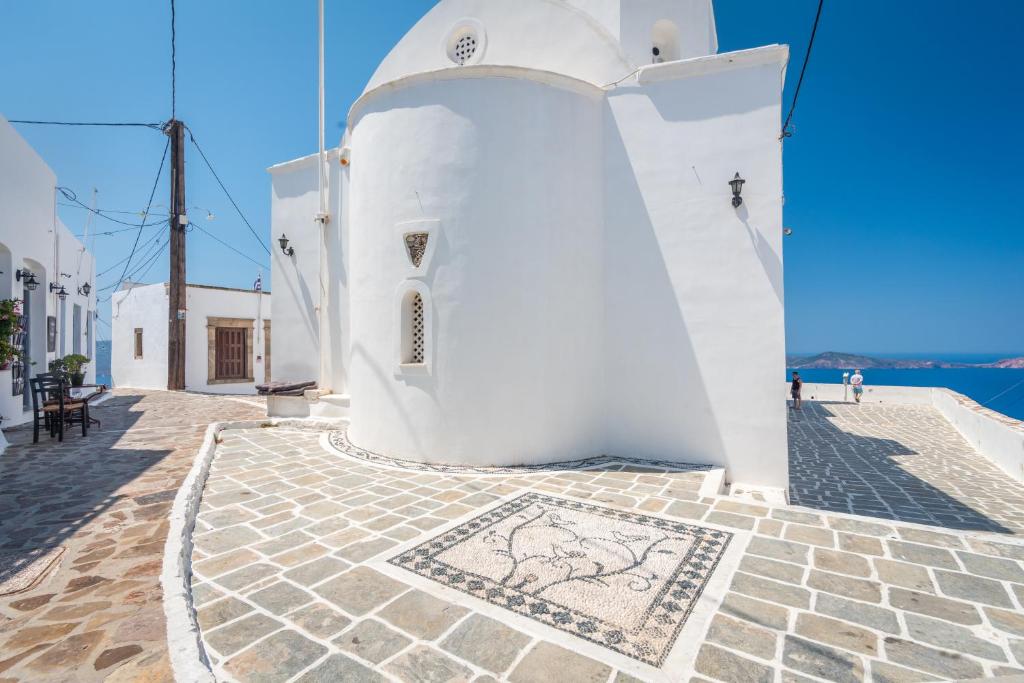 a white building with a mosaic floor in front of it at Sunset Nest in Plaka Milou