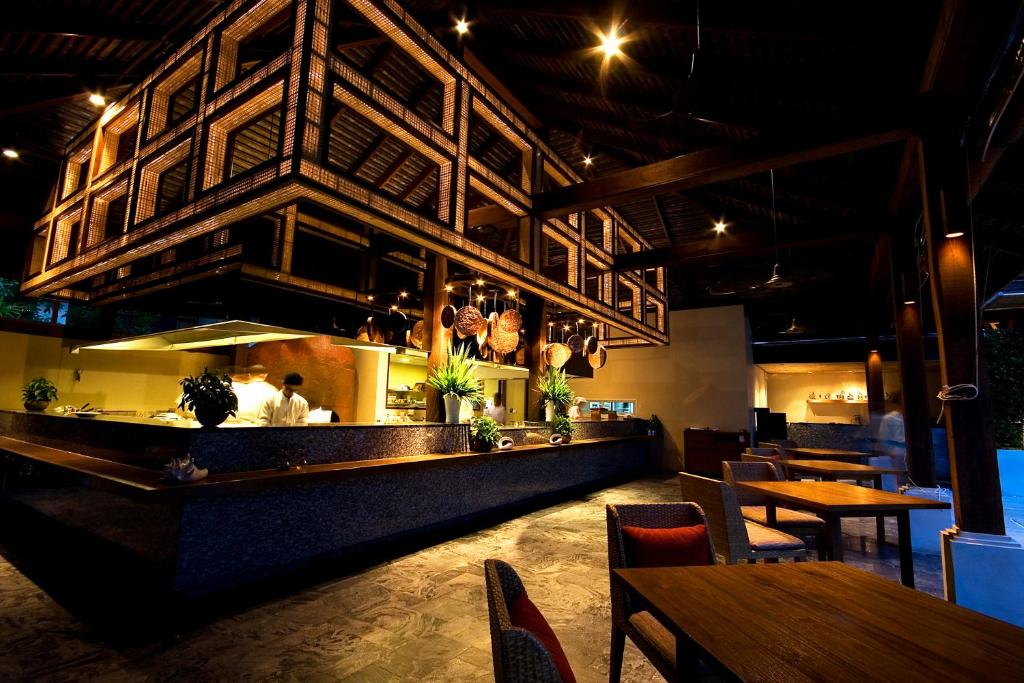 a restaurant with a bar with tables and chairs at Anantara Rasananda Koh Phangan Villas in Thong Nai Pan Noi