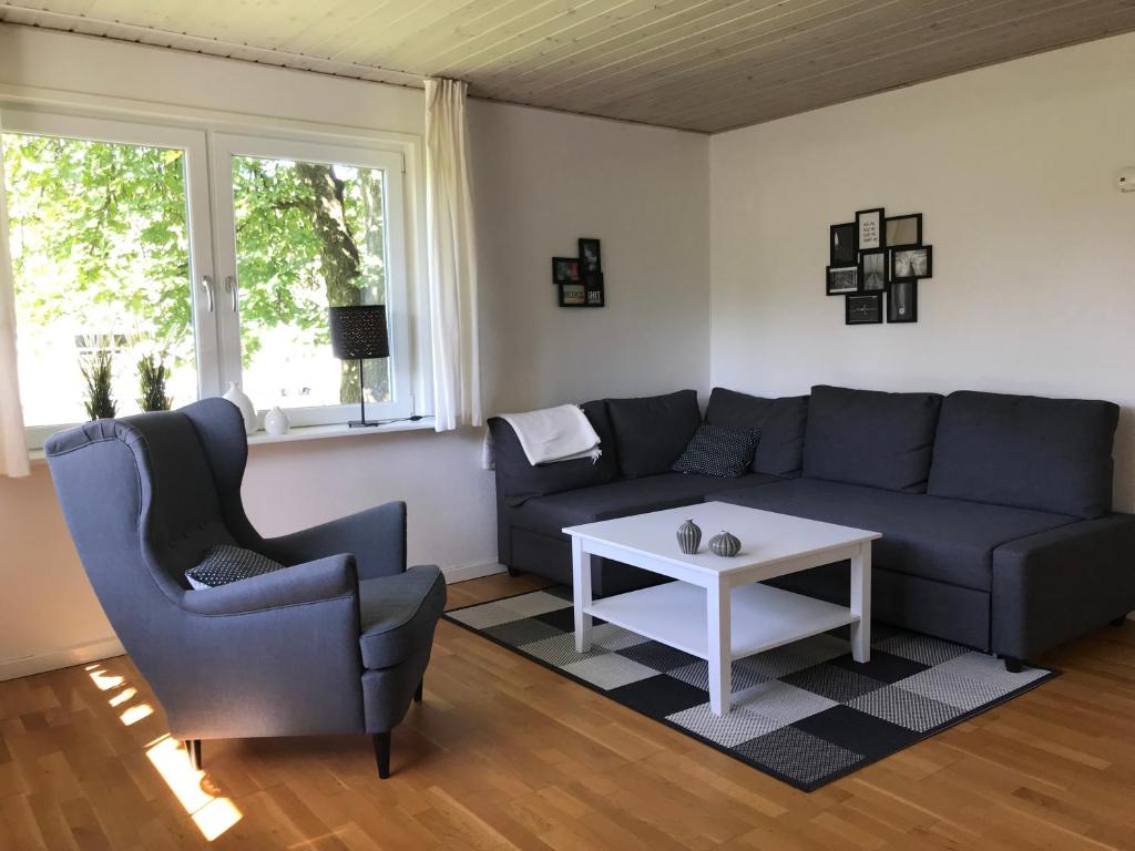 a living room with a couch and two chairs and a table at Det Bette Hus in Hjørring