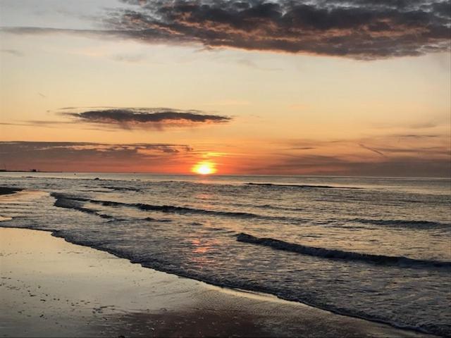 a sunset on a beach with the ocean at Det Bette Hus in Hjørring