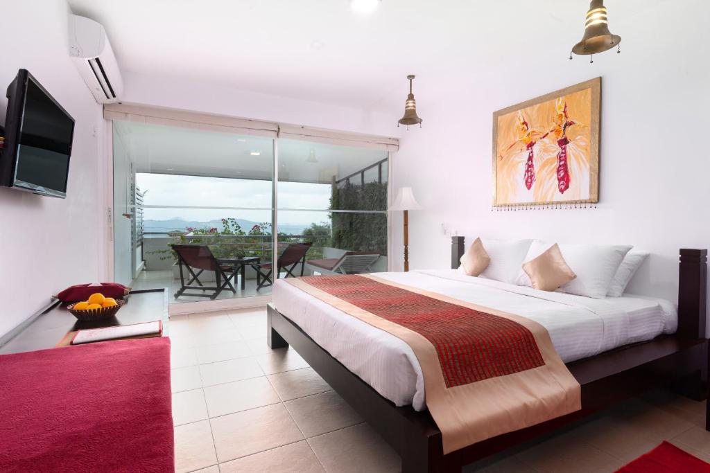 a bedroom with a large bed and a balcony at The Theva Residency in Kandy