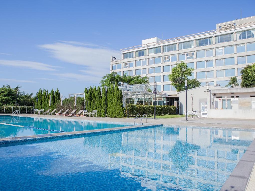 a large swimming pool in front of a building at Freshfields Hotel in Wuri