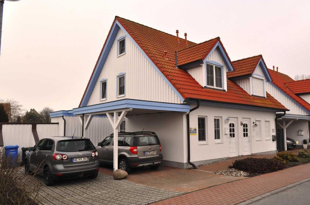 two cars parked in front of a house at Deichweg in Zingst