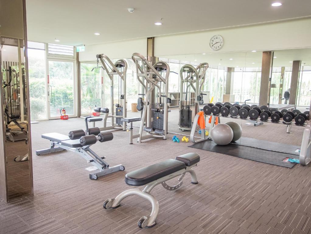 a gym with lots of machines and a clock at Freshfields Hotel in Wuri