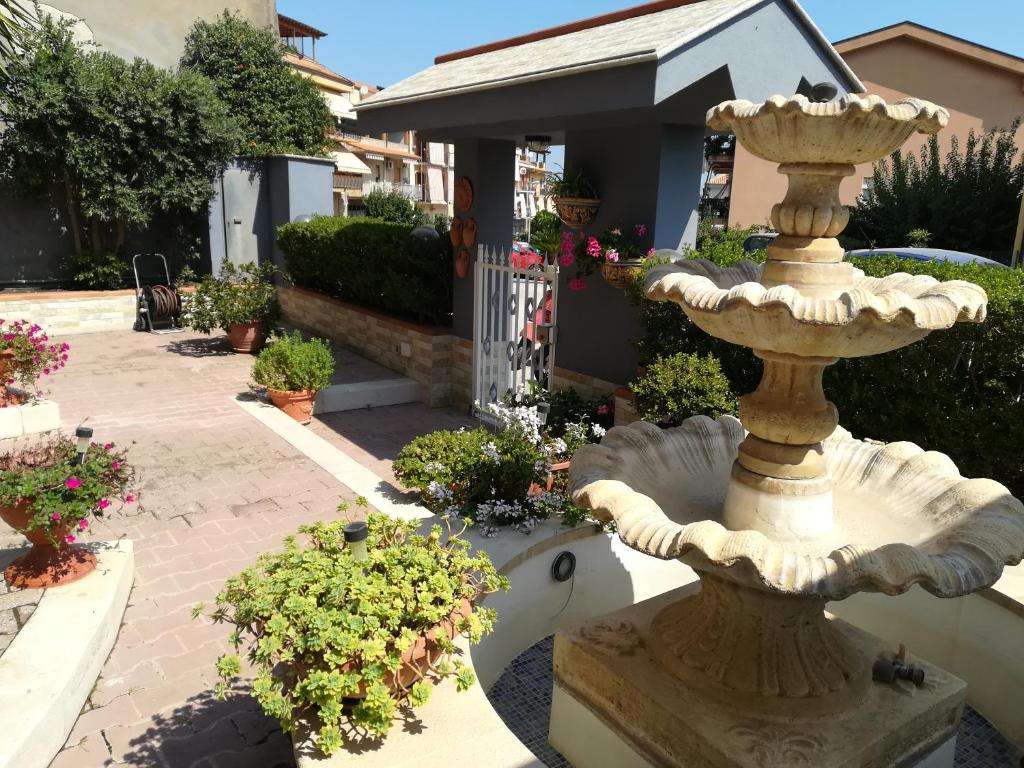 a stone fountain in a garden with flowers at B&B Ninni in Castelbuono