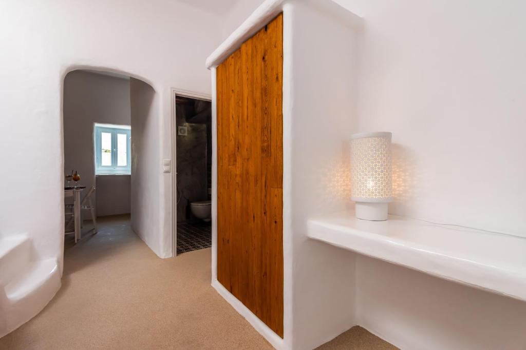 a bathroom with a wooden door and a mirror at Sunset Nest in Plaka Milou