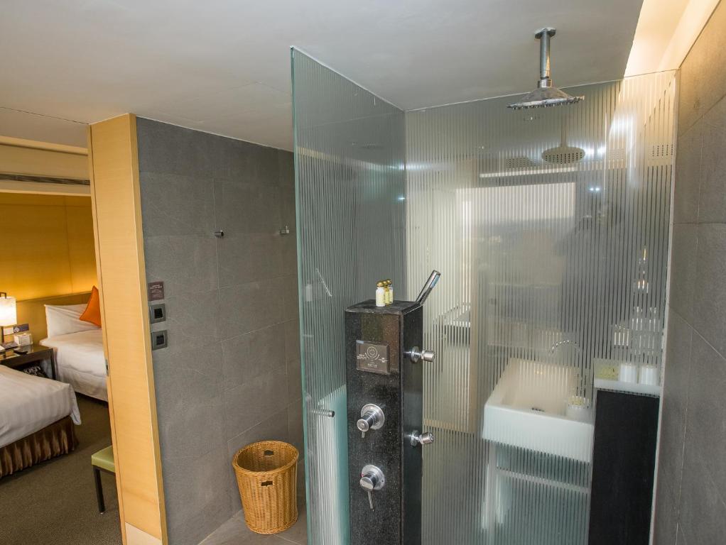a shower with a glass door in a room at Freshfields Hotel in Wuri