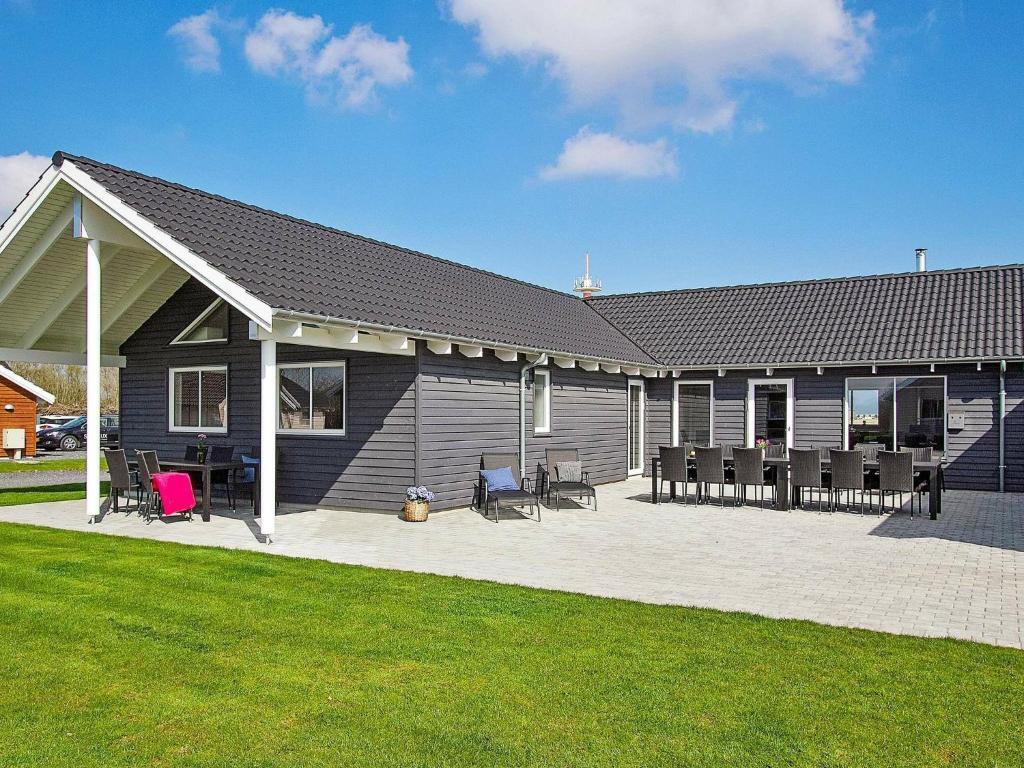 une maison avec des chaises et une terrasse en face de celle-ci dans l'établissement 20 person holiday home in Hasselberg, à Kappeln