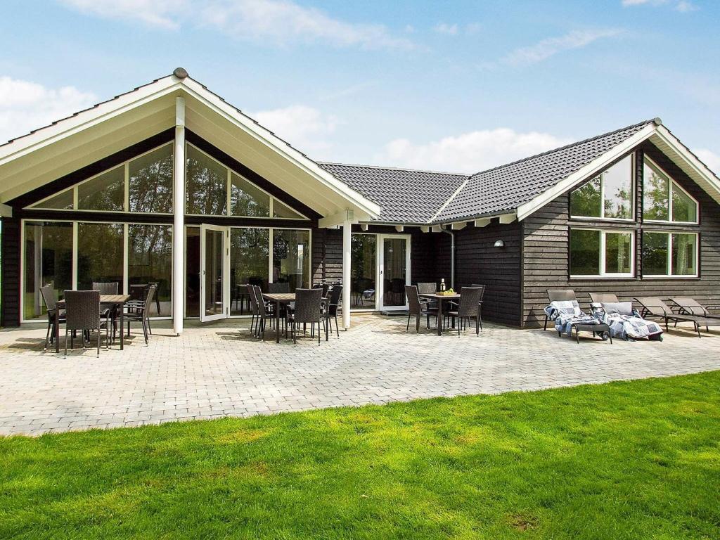 a house with a patio with tables and chairs at Holiday home Kappeln XIV in Kappeln