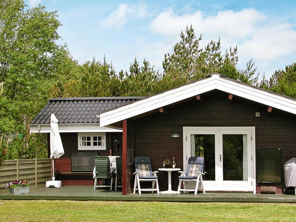 Casa pequeña con sillas y mesa en Three-Bedroom Holiday home in Ålbæk 48 en Ålbæk