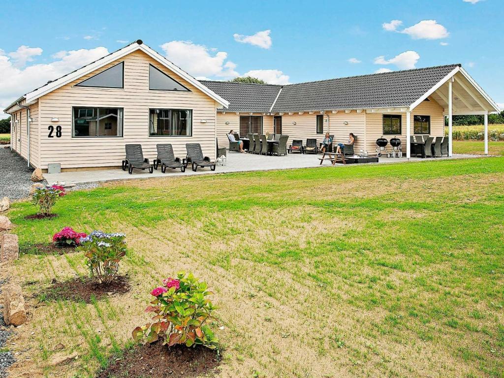 ein Haus mit einem großen Garten davor in der Unterkunft 22 person holiday home in Bogense in Bogense