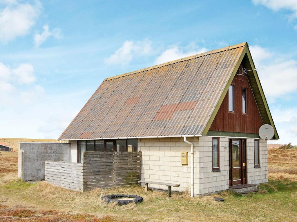 una pequeña casa blanca con techo de metal en 5 person holiday home in Harbo re en Harboør