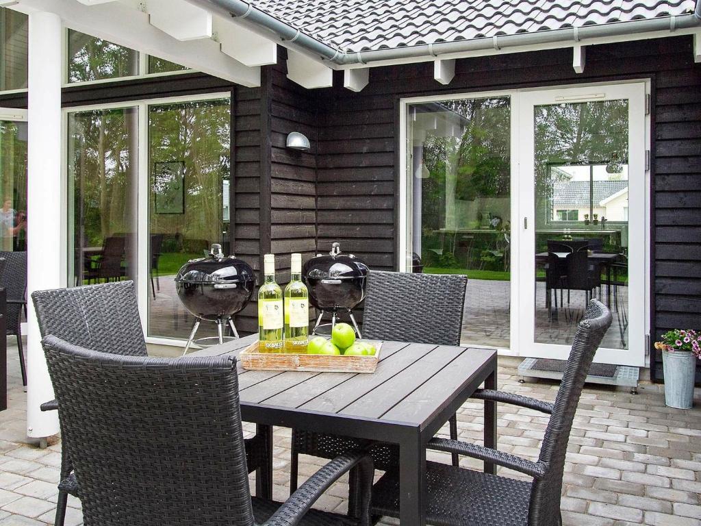 a wooden table with wine bottles and fruit on a patio at 16 person holiday home in Hasselberg in Kappeln