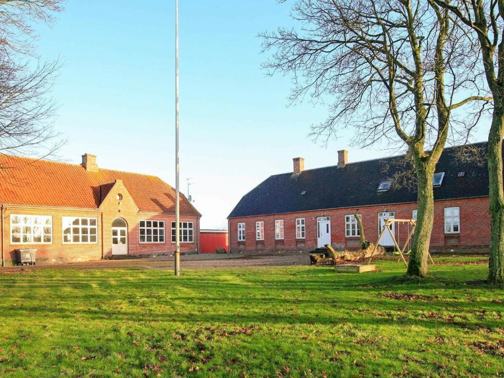 a large red brick building with trees in front of it at 26 person holiday home in Roslev-By Traum in Åsted