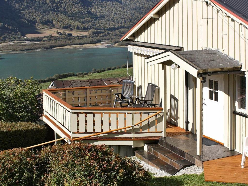 une maison avec une terrasse offrant une vue sur la rivière dans l'établissement 6 person holiday home in Otta, à Otta