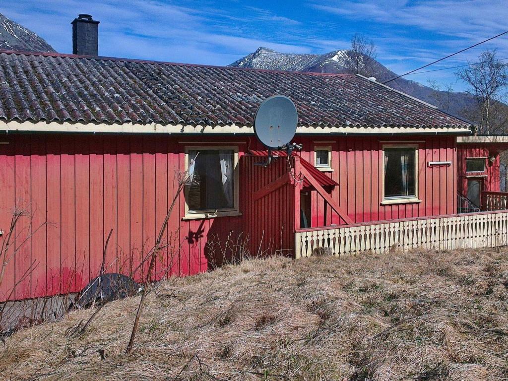 una casa roja con un espejo al costado. en Three-Bedroom Holiday home in Halsanaustan, en Korsnes