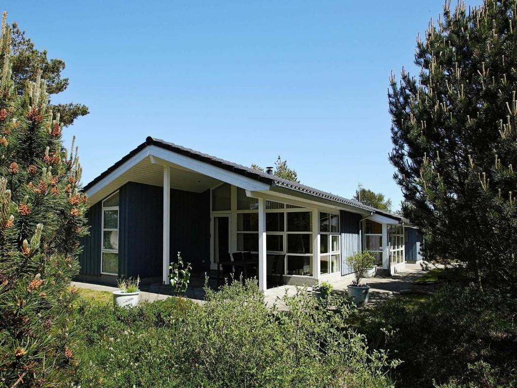 a blue house with trees in front of it at 10 person holiday home in Fjerritslev in Torup Strand