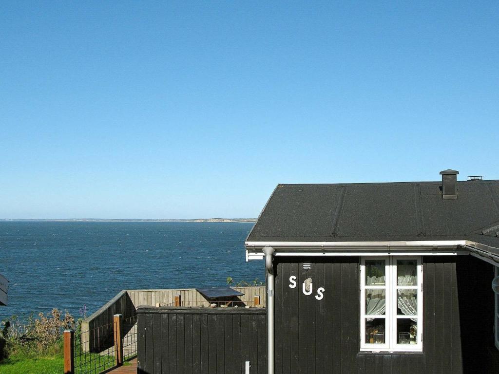 a black house with the ocean in the background at 4 person holiday home in Struer in Struer