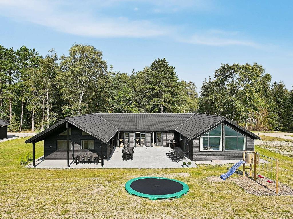 ein schwarzes Haus mit einem Trampolin davor in der Unterkunft Eight-Bedroom Holiday home in Frederiksværk in Melby